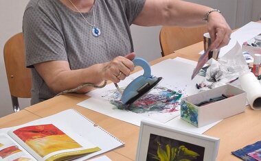 Dobrovolnice H .Vltavská ukazuje výtvarné techniky, tady na výstavě, tvoří taky s klienty AC dílen